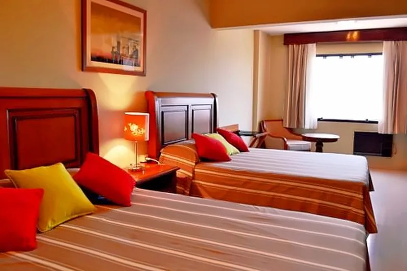 Habitación con dos camas y cojines de color